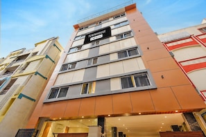 A multi-story building with a sign indicating it is serviced by OYO.