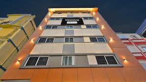 A multi-story building with a sign indicating it is serviced by OYO. - Townhouse Mindspace Road Gachibowli (Hyderabad)