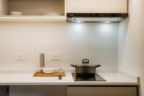 A kitchen with a stove, a pot, a bowl, and a wooden tray. - Hestia at Casa Solado (Buenos Aires)