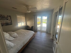 A bedroom with a bed, a ceiling fan, a chair, and a view through a door to an outdoor area. - Amazing Ranch Home located on a 155 acre ranch 10 minutes from downtown Paso. (Paso Robles)
