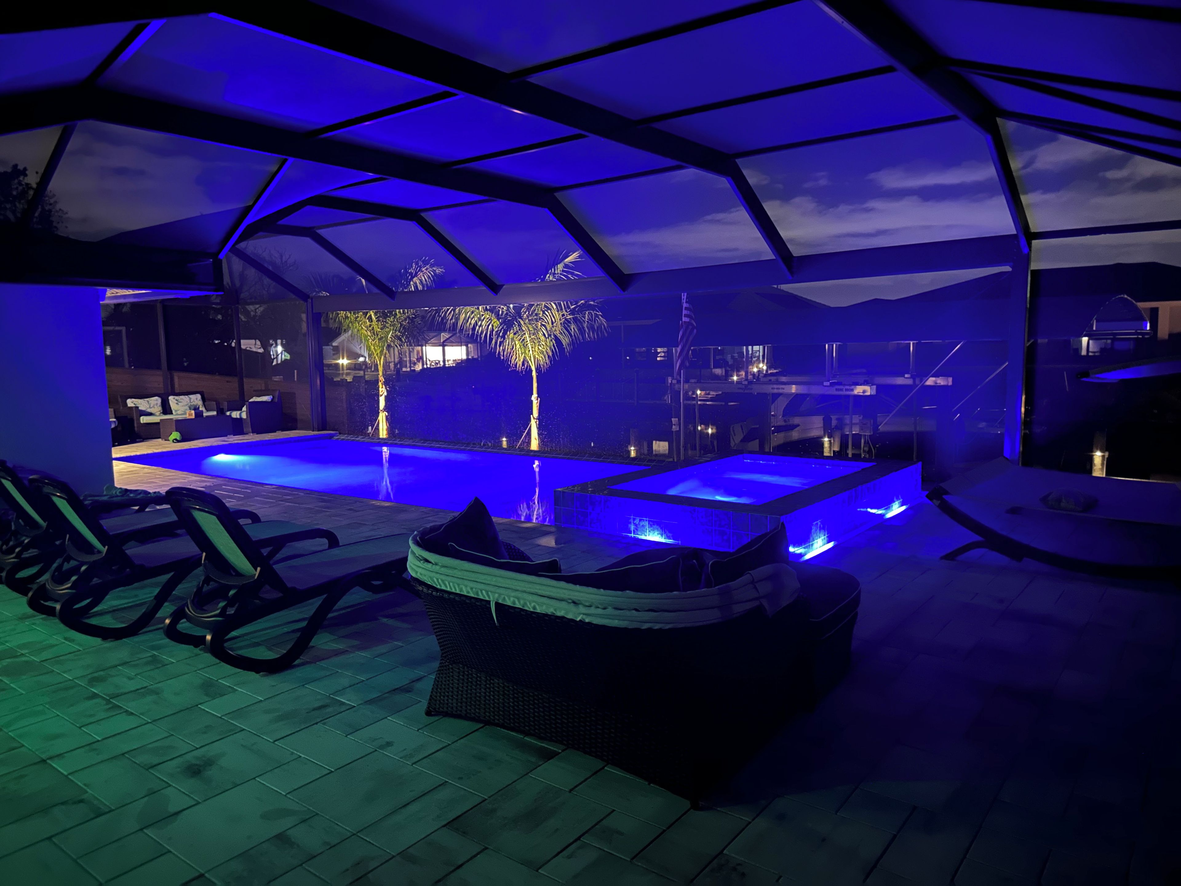 An outdoor pool area with a covered seating area and a view of a building in the background.