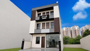 Un moderno edificio de hotel con entrada de vidrio y un letrero que indica que ofrece servicios de hotel.