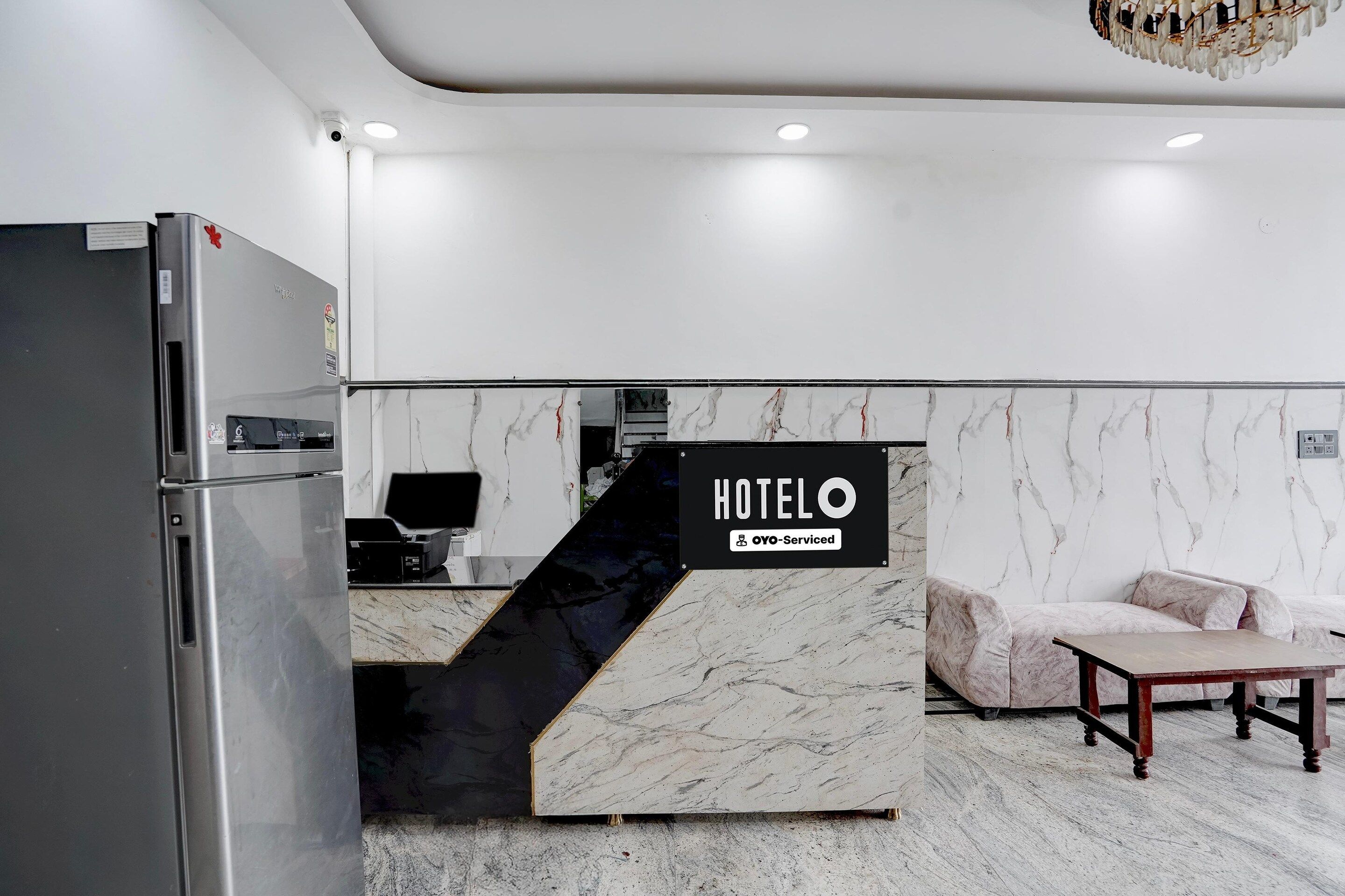 Ein Hotelrezeptionstresen mit einem Schild, das angibt, dass er von OYO verwaltet wird.
