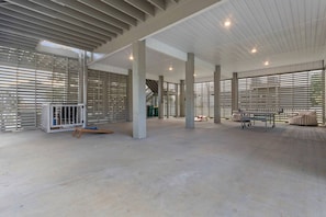 A spacious indoor area with high ceilings, large windows, and a central column structure.