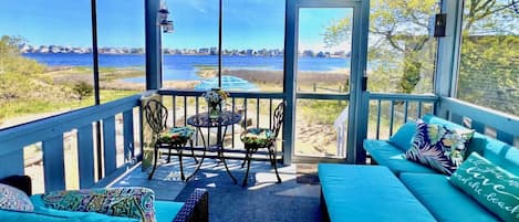 A covered outdoor seating area with a view of the water and beach.