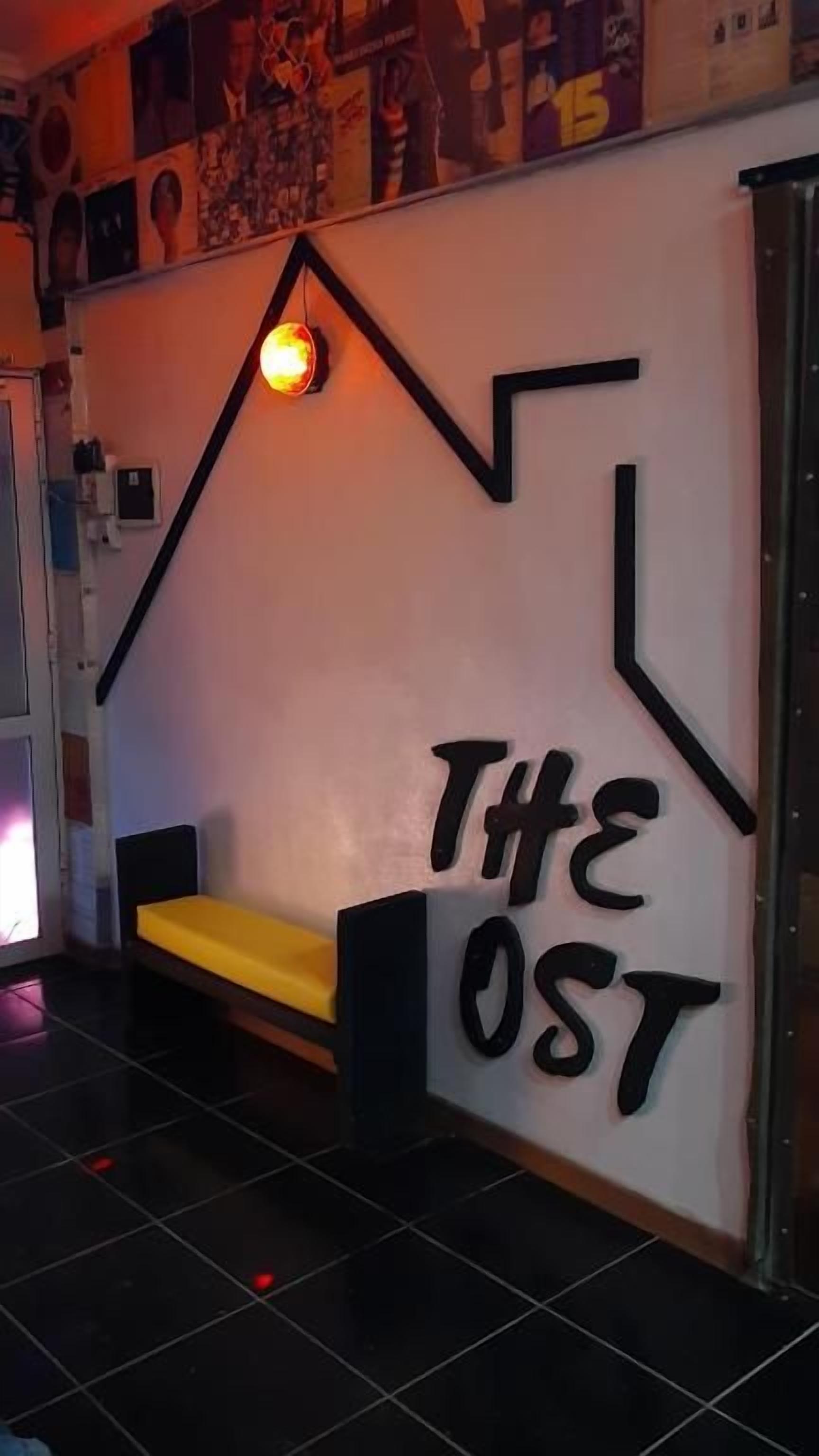 A wall with a geometric design and the text 'THE OST' in bold letters.