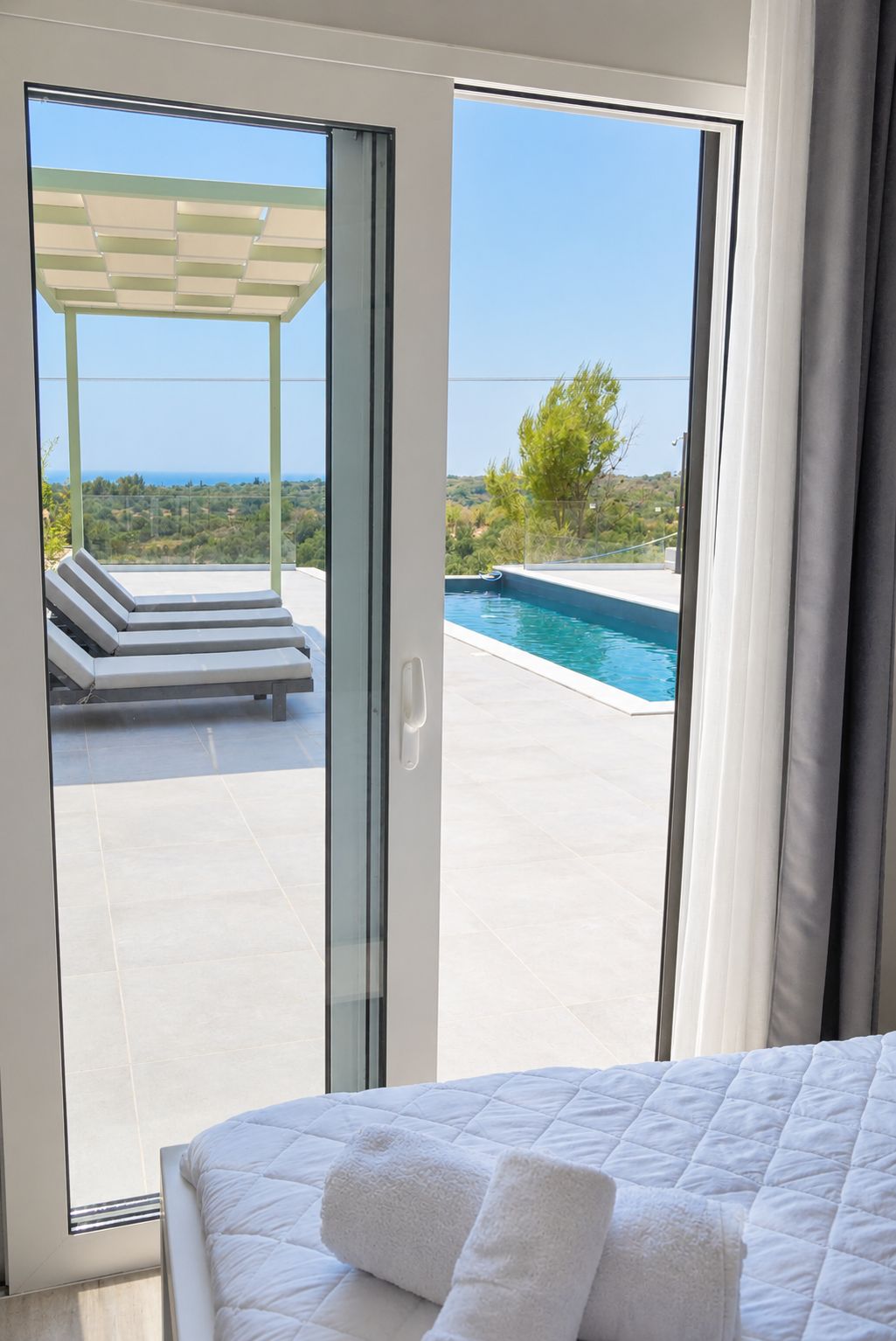 Un dormitorio con vistas a una piscina y sillas de descanso.