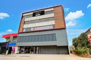 A multi-story building with a storefront featuring mannequins and a sign indicating a company name.