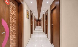 A hotel corridor with wooden doors, numbered 301, and a tiled floor.