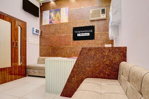 Un área de recepción con un mostrador de madera, un sofá y un radiador.