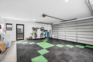 Un garage avec un sol à carreaux, des vélos et une porte de garage fermée.