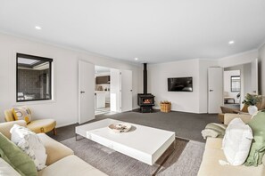 En moderne stue med en hvid sofa, et sofabord og en pejs.