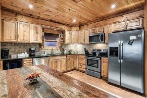 A kitchen with wooden cabinets, stainless steel appliances, and a wooden countertop. - Indoor Pool, Hot Tub & Game Room | Mountain Views, Minutes from Gatlinburg (Gatlinburg)