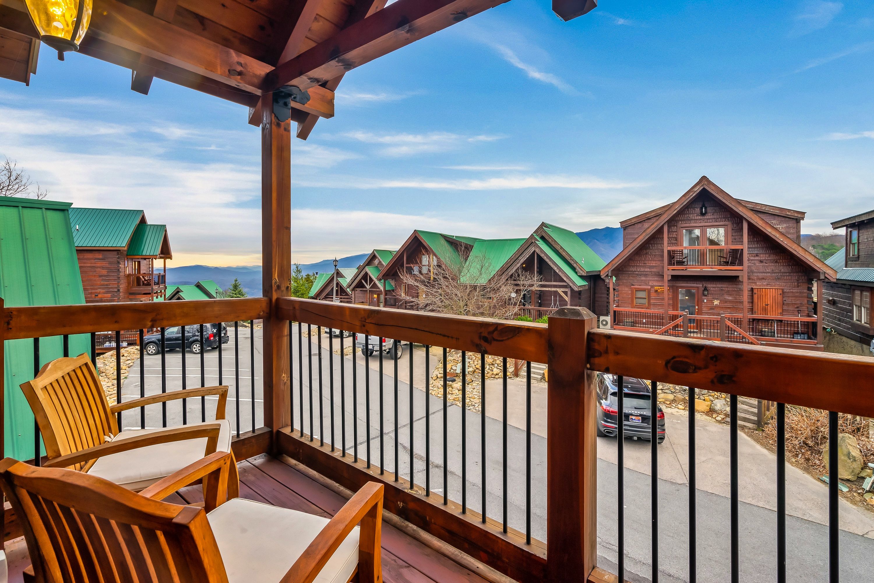 A wooden deck with a view of cabins and a street.