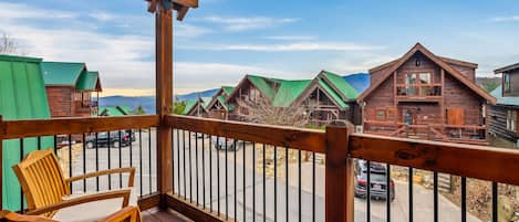 A wooden deck with a view of cabins and a street.