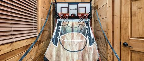 A basketball court with a wooden floor and a basketball hoop.