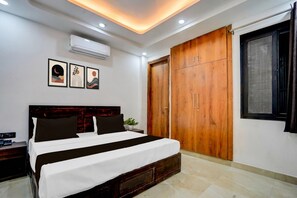 Un dormitorio con cama, armario y ventana.