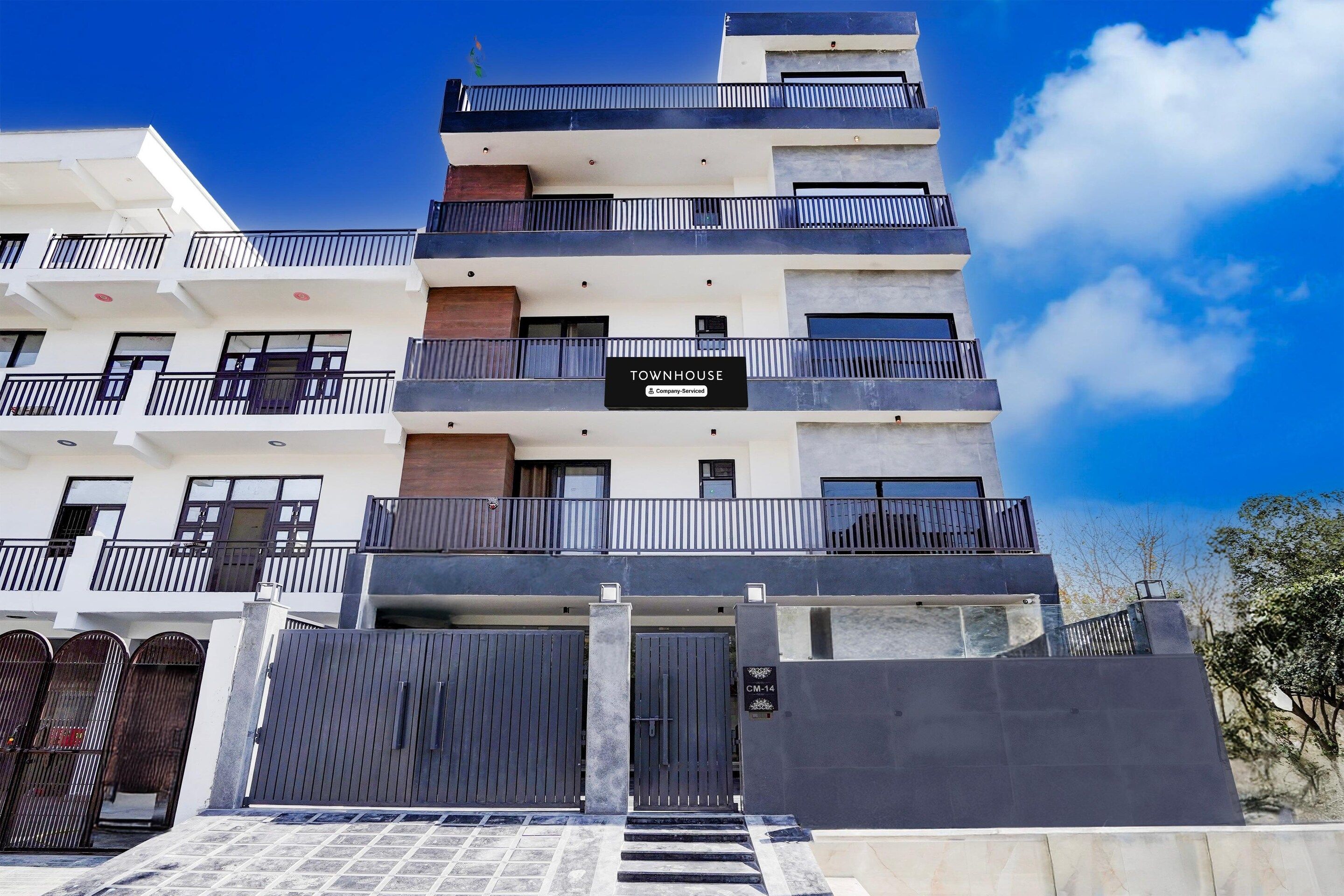 A multi-story building with a sign indicating 'TOWNHOUSE Company Serviced.'