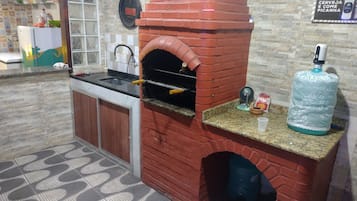 A kitchen with a brick oven, granite countertop, and a water dispenser.