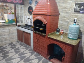 A kitchen with a brick oven, granite countertop, and a water dispenser.