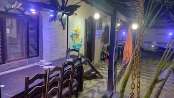 Uma sala de jantar com uma mesa comprida e cadeiras, uma parede com um logotipo e um chão estampado.