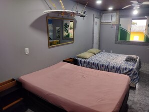 Un dormitorio con una cama individual, una mesita de noche, un espejo y un ventilador de techo.