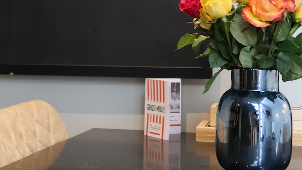 Ein Tisch mit einer Blumenvase und einem Bild von Lippen.