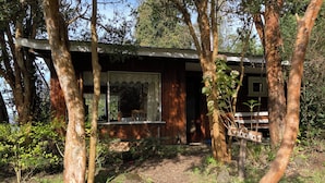 A rustic cabin with a wooden exterior, a covered porch, and a sign indicating 'Cabaña 1'. - Cabañas el Bosque Patagónico (Frutillar)