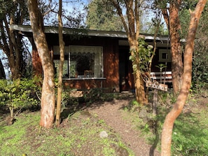 Une cabane rustique avec une façade en bois, une véranda couverte et une pancarte indiquant « Cabane n° 1 ».