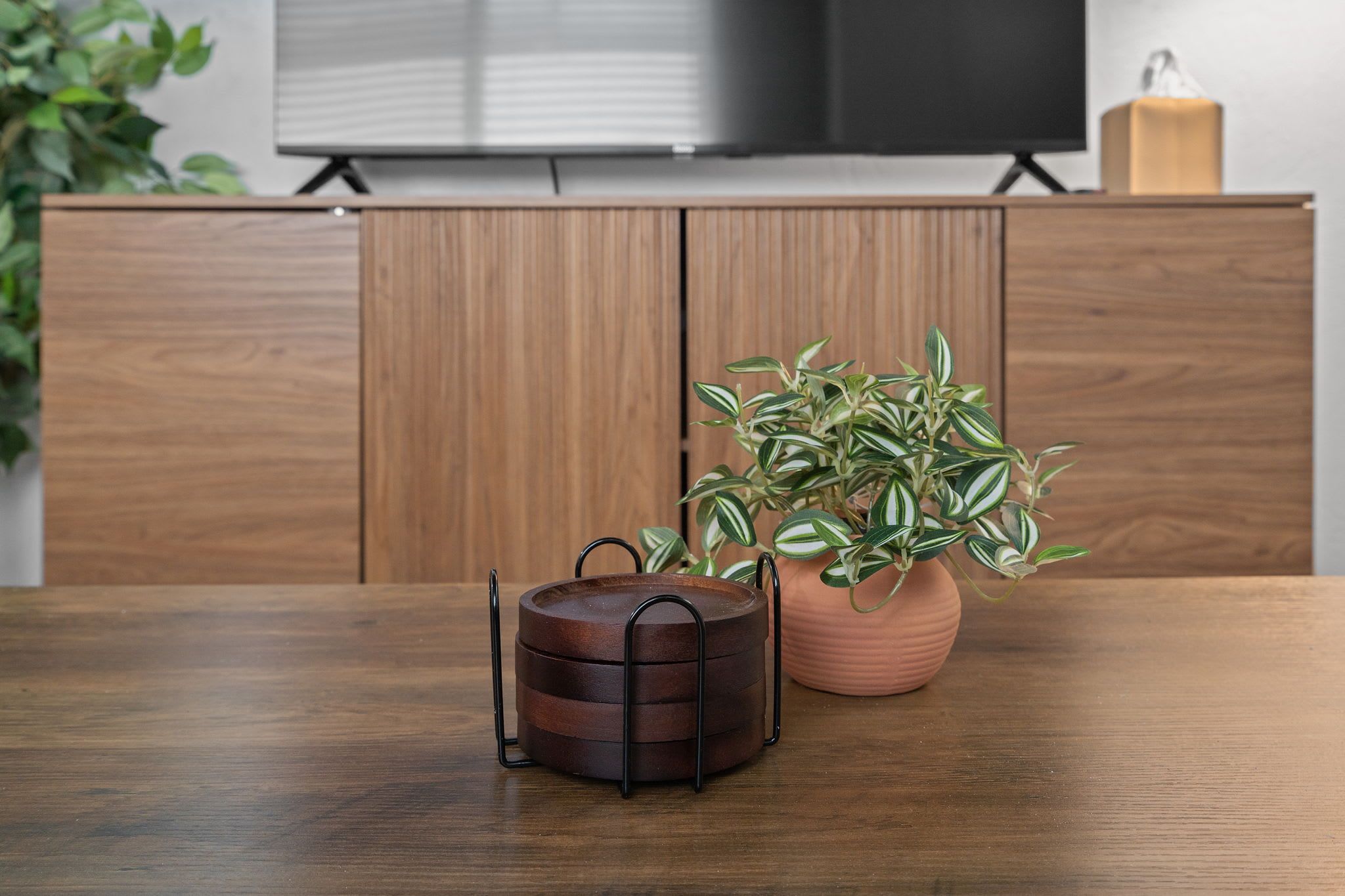 A wooden table with a potted plant and a metal container.