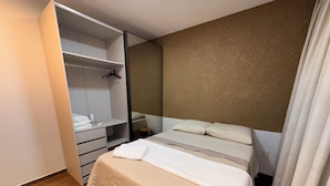 A bedroom with a bed, a wardrobe, and a mirror. - Modern Apartment with Ocean View, Praia do Futuro | Air Conditioning and Parking Space. (Fortaleza)