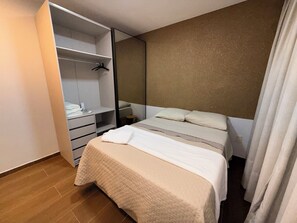 Ein Schlafzimmer mit einem Bett, einem Kleiderschrank und einem Spiegel.