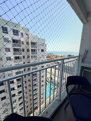A balcony with a view of a swimming pool and buildings. - Modern Apartment with Ocean View, Praia do Futuro | Air Conditioning and Parking Space. (Fortaleza)