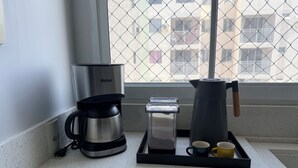 A kitchenette with a coffee maker, a water dispenser, and a coffee pot on a countertop. - Modern Apartment with Ocean View, Praia do Futuro | Air Conditioning and Parking Space. (Fortaleza)