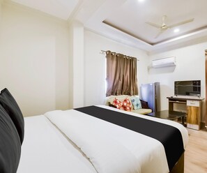 A hotel room with a bed, a desk, a television, and an air conditioning unit. - Saver Double Hotel Grey Jade (Vasco da Gama)