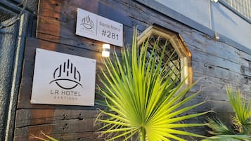 A wooden building with signs for 'Santa Maria #281' and 'LR Hotel Santiago'.
