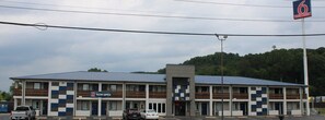 Un motel con facciata a scacchi, diversi balconi e un parcheggio.