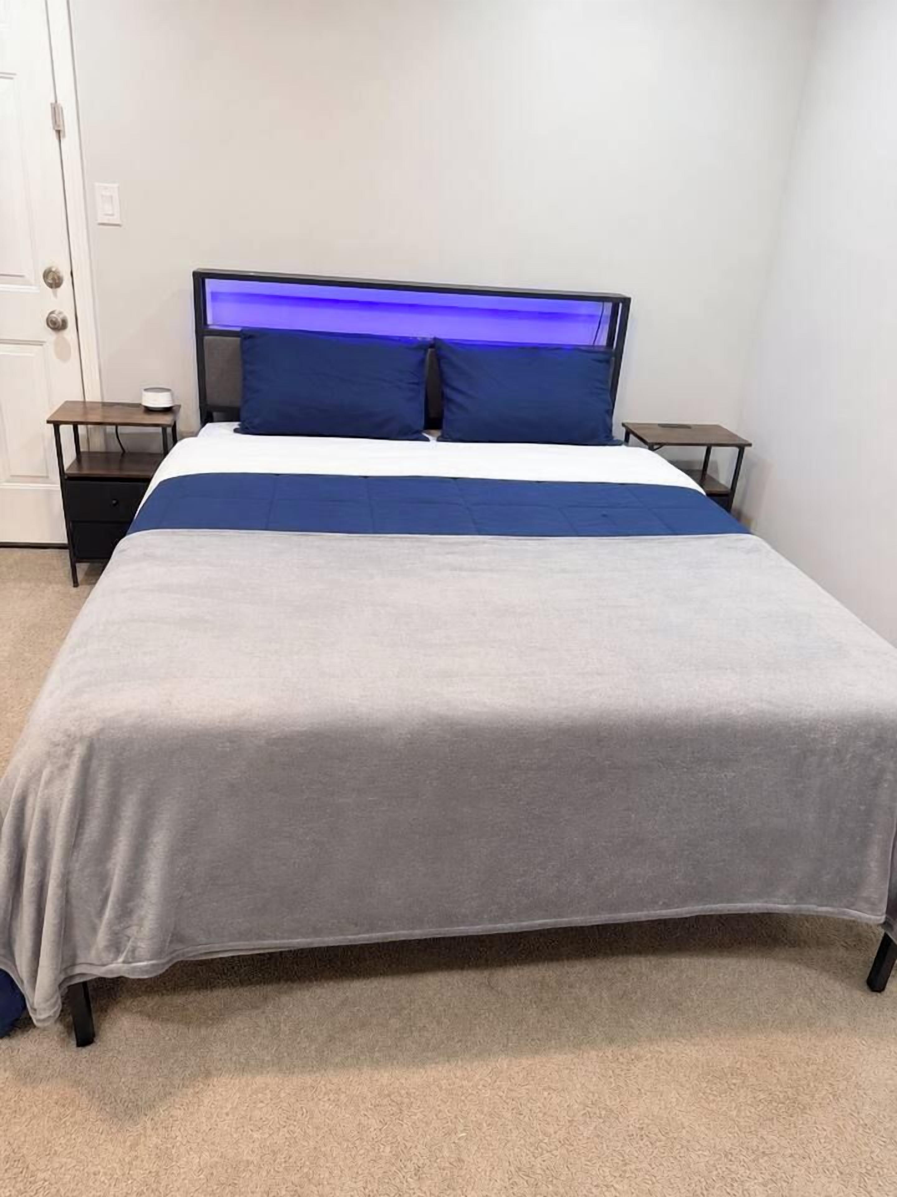 A single bed with a headboard, a bedside table, and a nightstand.