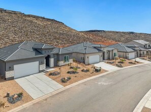 A residential area with houses featuring grey roofs and stone accents, surrounded by a hilly landscape. - 3 Master Suites with Private Baths, Kings Beds, Private Hot Tub, EV, BBQ (Washington)