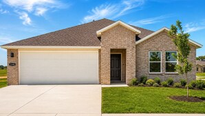 A single-story house with a garage, a brick exterior, and a well-maintained lawn.