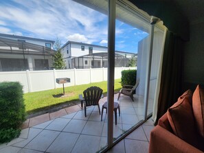 A patio with a glass door, a white fence, and a grill. - BBQ Grills, Free Shuttle to Disney and more  # 5 (Orlando)
