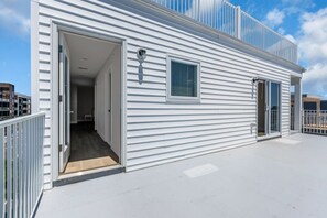 A modern building with a flat roof, a sliding glass door entrance, and a small window. - Luxury Ocean-Block Penthouse, Ocean Views (Seaside Heights)