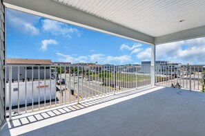 A covered outdoor area with a view of a parking lot and buildings in the background.