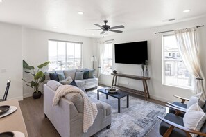 A modern living room with a sofa, coffee table, and a flat-screen TV. - Sleeps 10, Pet-Friendly, Arcade, EV Charger, Perfect Location (Washington)