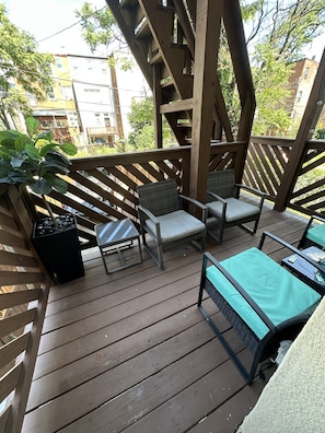 A wooden deck with outdoor furniture, including chairs and a table. - Eclectic Comfort: The Kitt – 2BR/2BA w/ Balcony Near MICA & JHU (Baltimore)