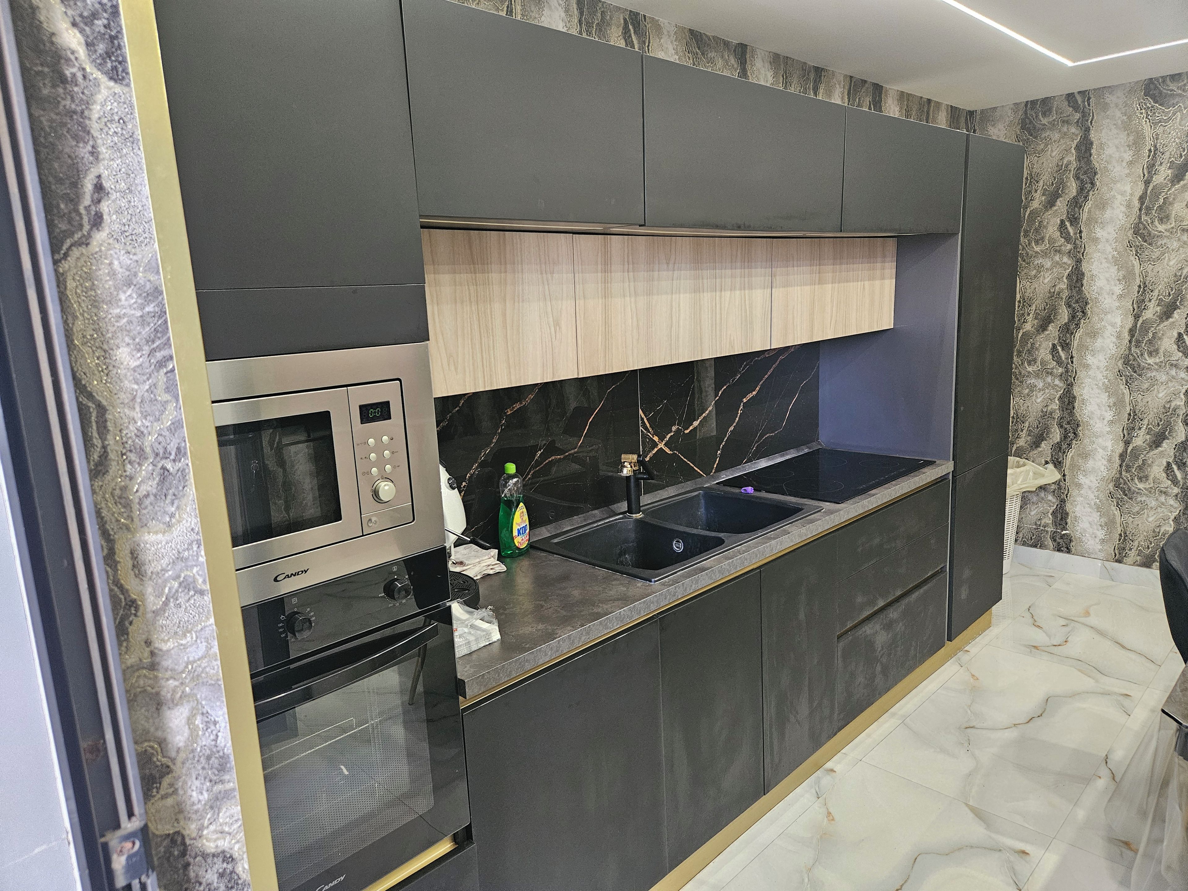 Eine moderne Küche mit eingebauter Mikrowelle, Backofen und Spüle.