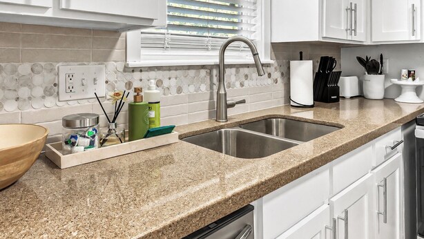 A kitchen with white cabinets, a granite countertop, a double sink, and a window with blinds. - Northgate: Closest Home to Aggieland! 3BR, 2.5BA (College Station)