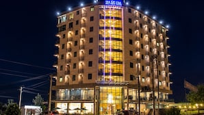 A multi-story hotel with a prominent sign at the top, large windows, and balconies.