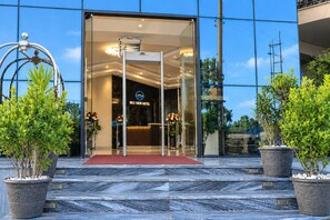 The entrance of Nile View Hotel with a glass facade, a reception desk, and potted plants.