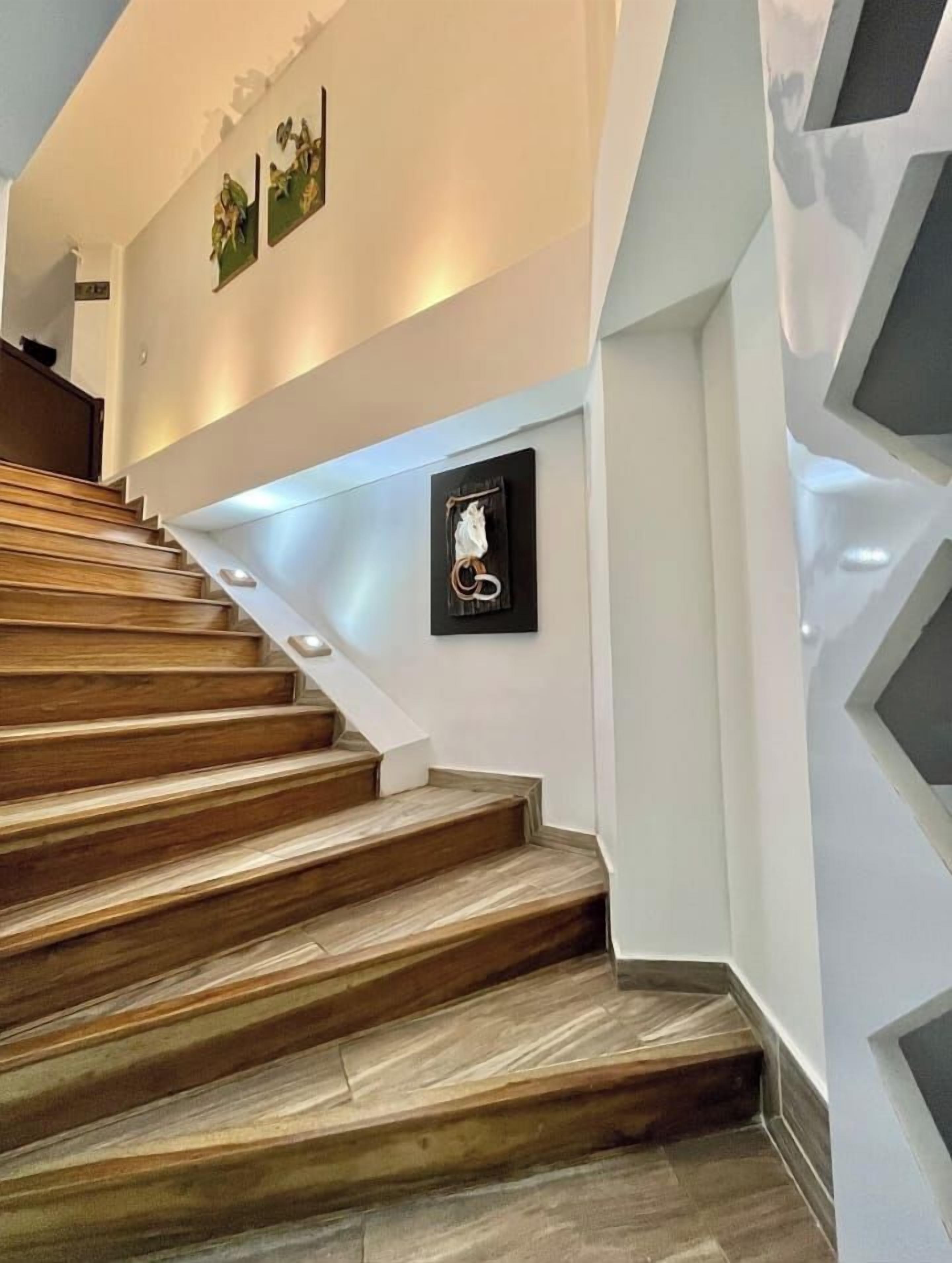 Eine Treppe mit Holzsstufen und einem an der Wand befestigten Bilderrahmen.